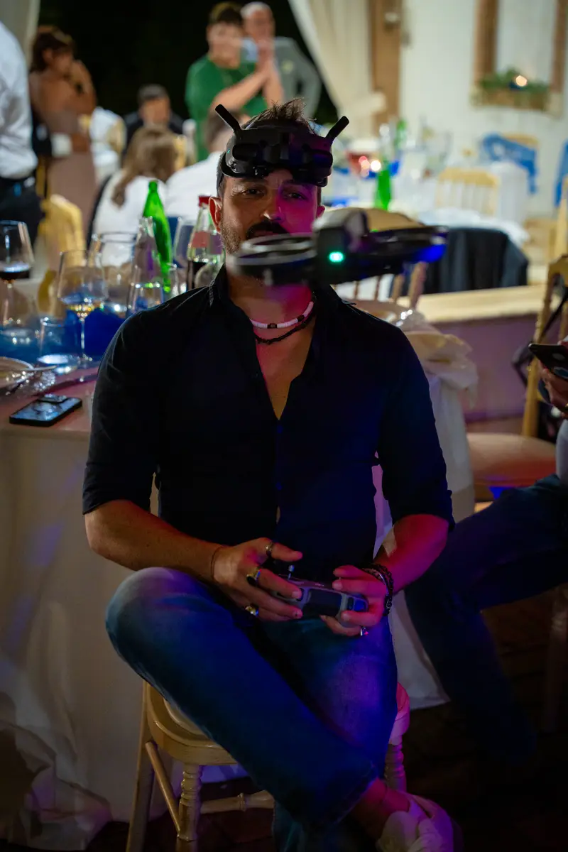 Dronista con visore e radiocomando a una festa